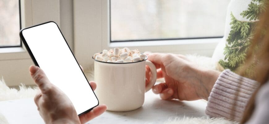 Woman,Drinking,Coffee,And,Hold,Smartphone.,Cozy,Winter,Holiday.,Winter