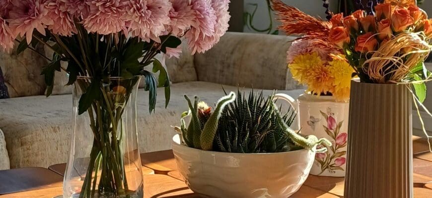 Dining Table with Two Vases of Flowers and a Bowl